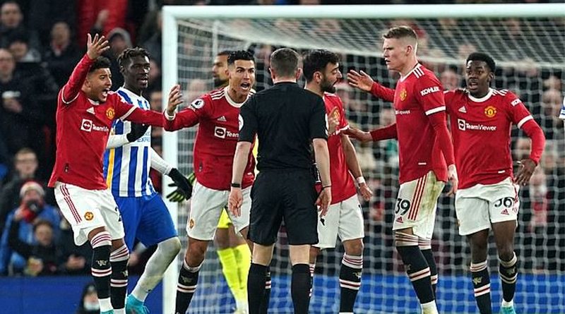 Manchester United players surround referee Mr Bankes to demand Lewis Dunk is sent off during their 2-0 win over Brighton